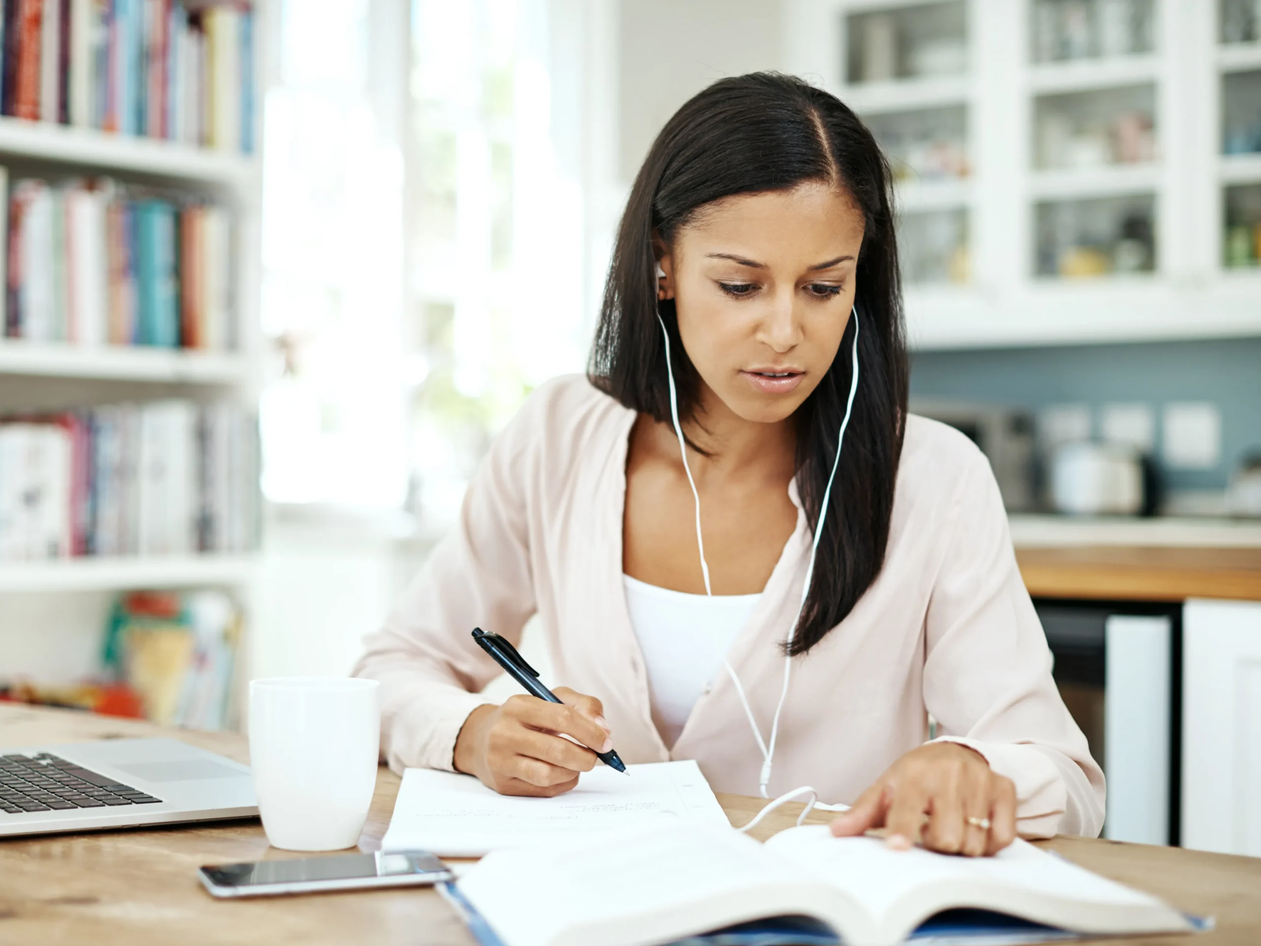 woman reading book and listening to music with ear buds