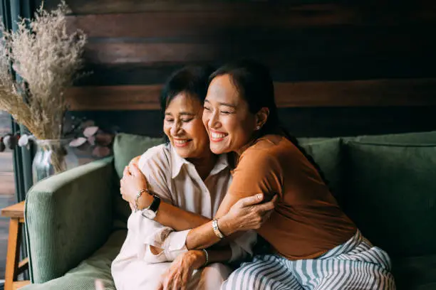 elderly woman and her daughter hugging and smiling