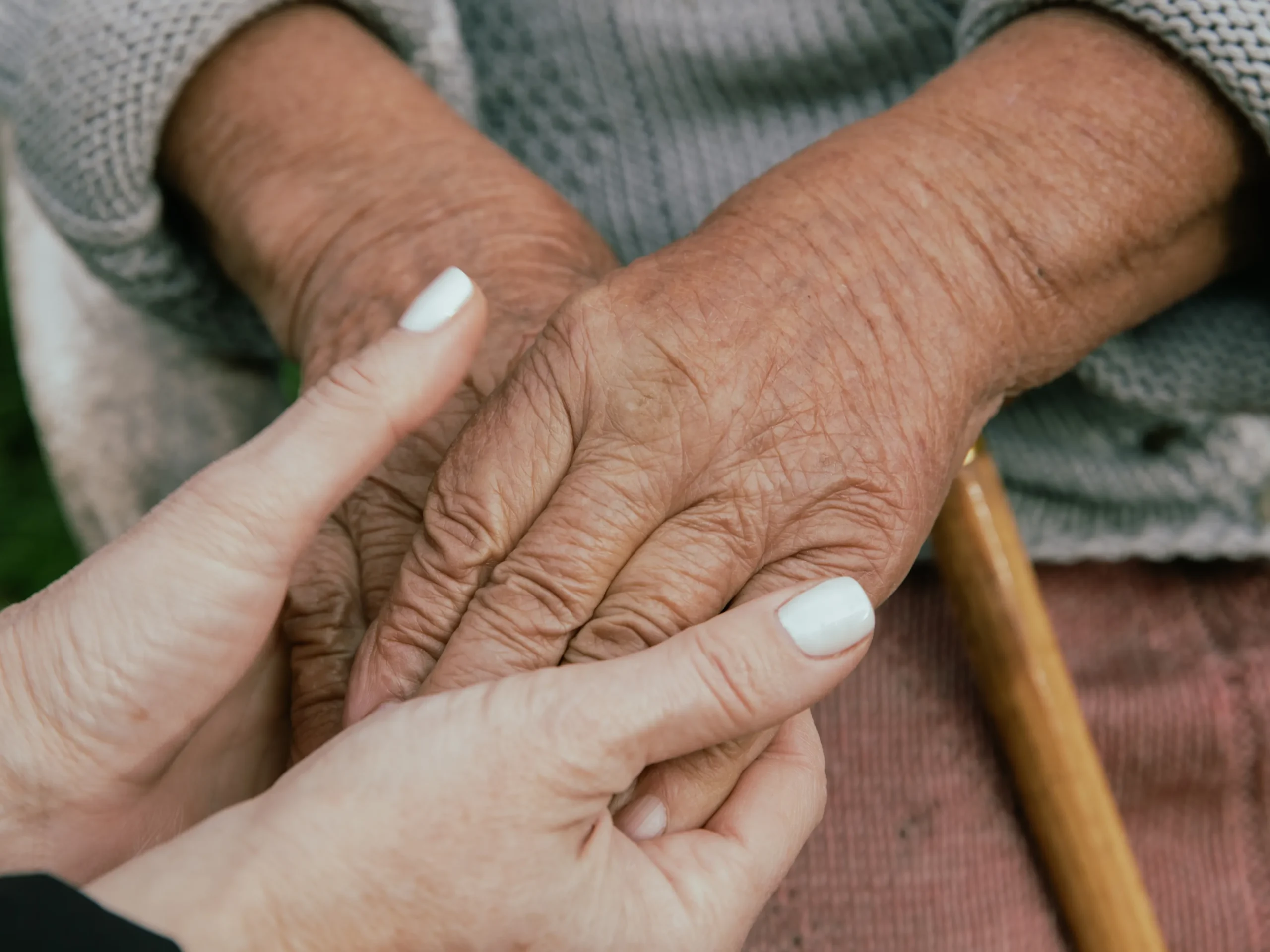 woman's hands holding elderly hands - signifying the importance of in-home respite care services